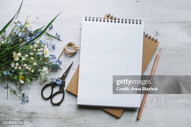 blank note pad, scissors, pencil and bunch of wild blue and white flowers. copy space for text. creativity concept. - white flower paper stock pictures, royalty-free photos & images