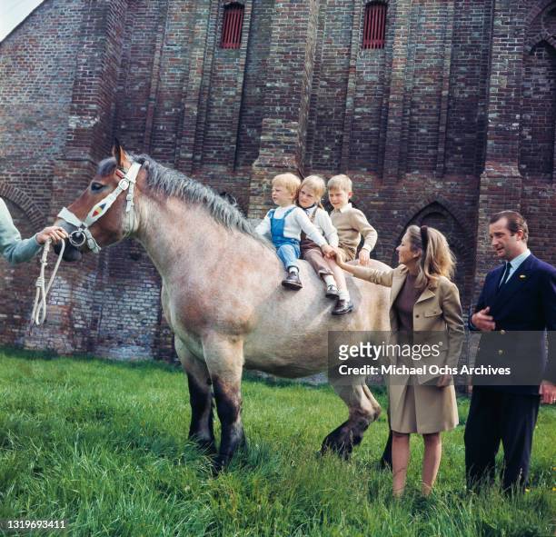 Belgian Royals Prince Laurent of Belgium, Princess Astrid of Belgium and Prince Philippe of Belgium riding a pony alongside their parents, Paola,...