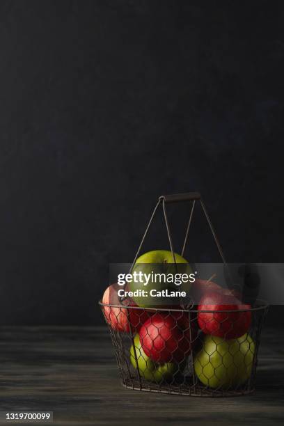 still life background with apples in wire basket - red apple stock pictures, royalty-free photos & images