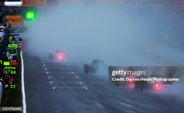 Responding to a green light displayed on the start & finish straight, Formula One cars throw up large clouds of water spray as they're released from...