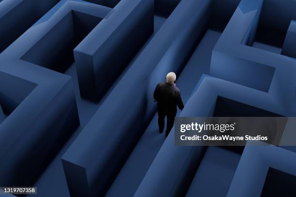 high angle view of male figure walking through maze. - alzheimers stock-fotos und bilder