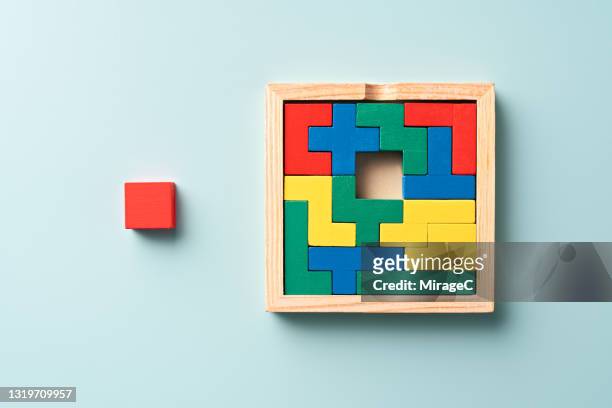 colorful wooden puzzle with a final piece - jigsaw piece ストックフォトと画像