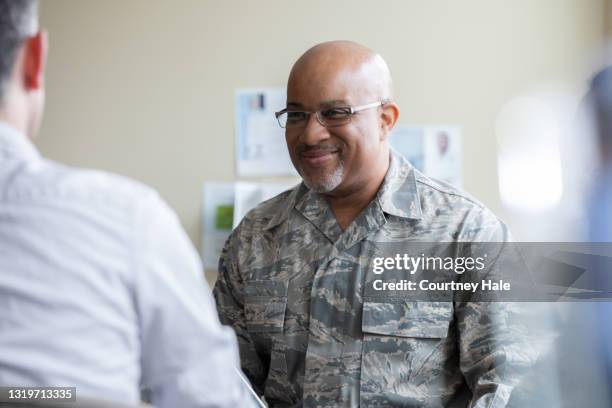 hombre militar de alto rango sonriendo durante discusión de terapia de grupo - military uniform fotografías e imágenes de stock