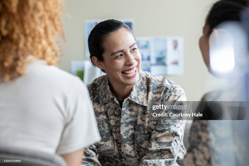 Adult military woman smiling during group therapy discussion