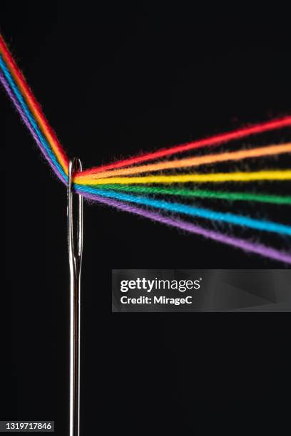 rainbow colored threads through needle eyelet - needle point stock pictures, royalty-free photos & images
