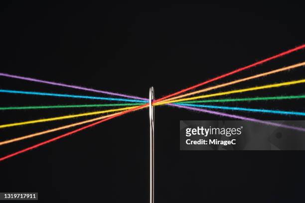 rainbow colored threads through needle eyelet - sewing needle stock pictures, royalty-free photos & images