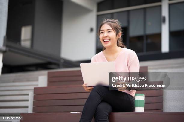 focused young women student sitting on stairs using a laptop - holding laptop stock pictures, royalty-free photos & images