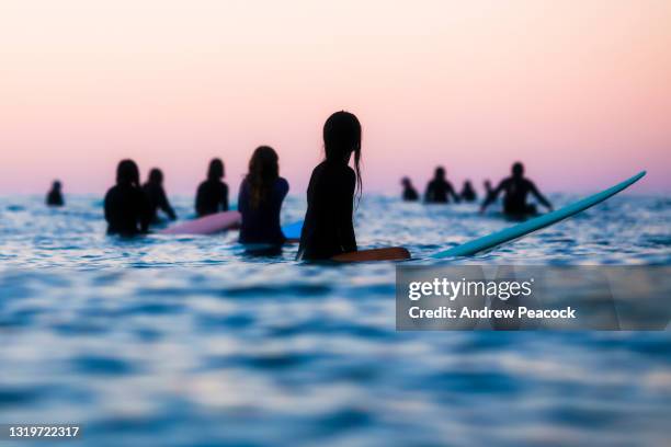 surfers attendant dans l’océan pour une vague. - surf photos et images de collection