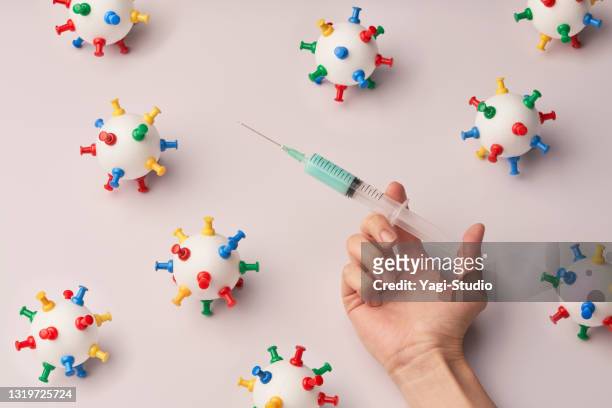 handmade model of coronavirus and coronavirus vaccine syringe - uncertainty pandemic stock pictures, royalty-free photos & images