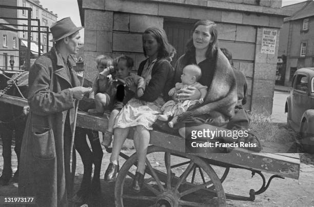 Gypsy mothers and their children sit on a cart in a Galway street, Ireland, 1945. Original Publication : Picture Post - 2082 - Off To The Galway...
