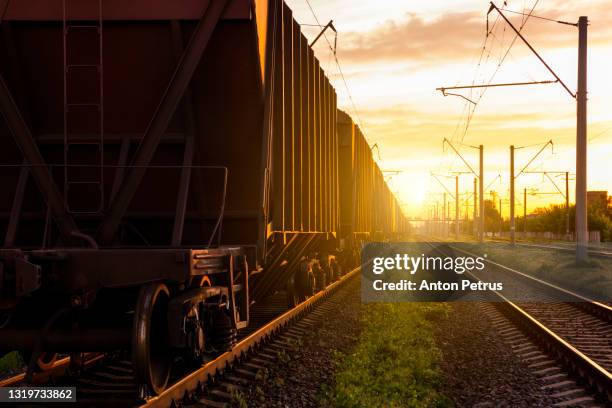 freight wagons on the railroad at sunset. rail freight and passenger transportation - güterzug stock-fotos und bilder