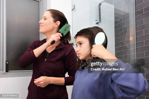 mother and daughter brushing hair together - haare kämmen stock-fotos und bilder
