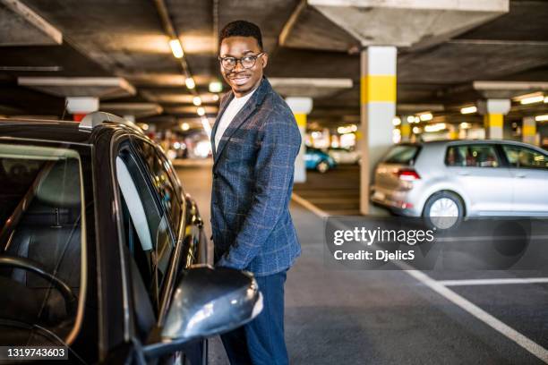 homme d’affaires heureux entrant sa voiture au garage de stationnement de voiture. - black car photos et images de collection