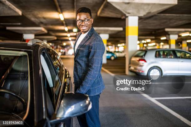 happy businessman entering his car at car parking garage. - parking imagens e fotografias de stock