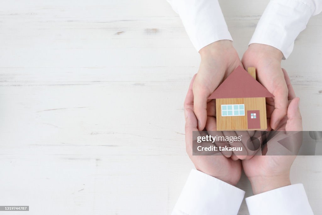 Couple's hands with house object