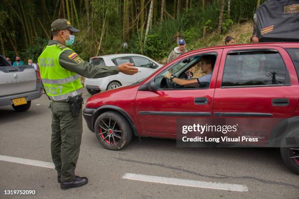 Colombian transit police officers help civilians in cars stuck on the blockade turn back and use alternate routs as National truckers strike at...