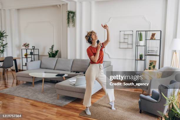 beautiful woman listening music at home - woman indoors stock pictures, royalty-free photos & images