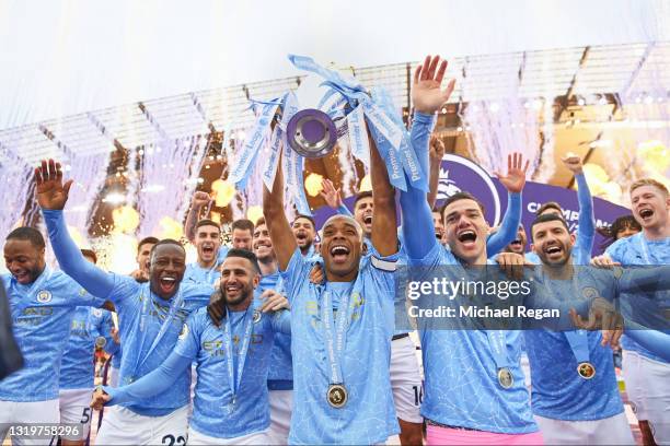 Fernandinho of Manchester City lifts the Premier League Trophy with team mates Benjamin Mendy, Riyad Mahrez, Ederson and Sergio Aguero as Manchester...