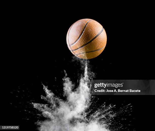 impact and rebound of a ball of basketball on a surface of land and powder on a white background - valencia basket stock-fotos und bilder