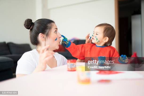 de moeder en haar weinig leuke dochter spelen met vingerverf. - vingerverf stockfoto's en -beelden