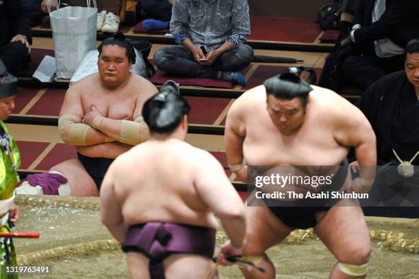 Ozeki Terunofuji watches the bout between ozeki Takakeisho and Endo during day thirteen of the Grand Sumo Summer Tournament at Ryogoku Kokugikan on...