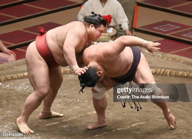 Sekiwake Takayasu sends Myogiryu out of the ring to win during day thirteen of the Grand Sumo Summer Tournament at Ryogoku Kokugikan on May 21, 2021...