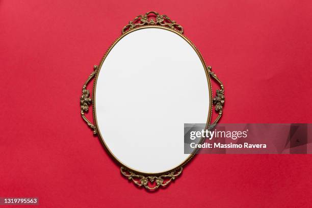 golden oval frame on red background - decoración objeto fotografías e imágenes de stock