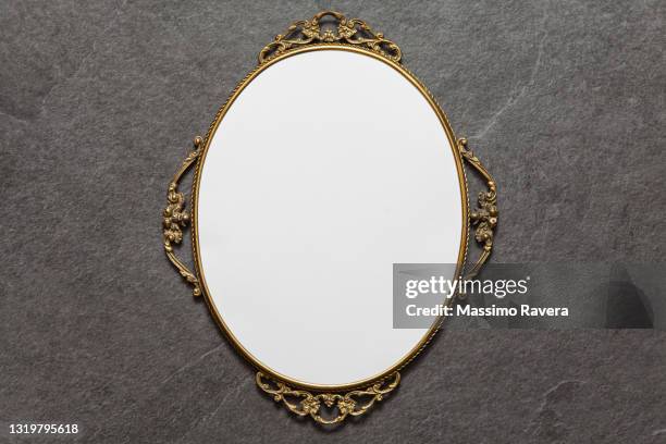 golden oval frame on stone background - mirror frame stock-fotos und bilder