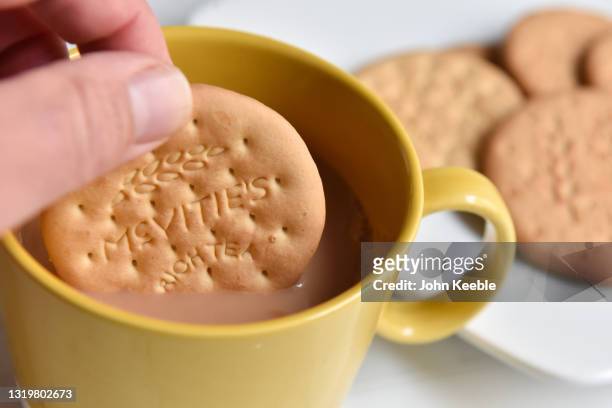 In this photo illustration, a McVitie's Rich Tea biscuit is dunked into a cup of tea on May 24, 2021 in Unspecified, United Kingdom. McVitie's’...