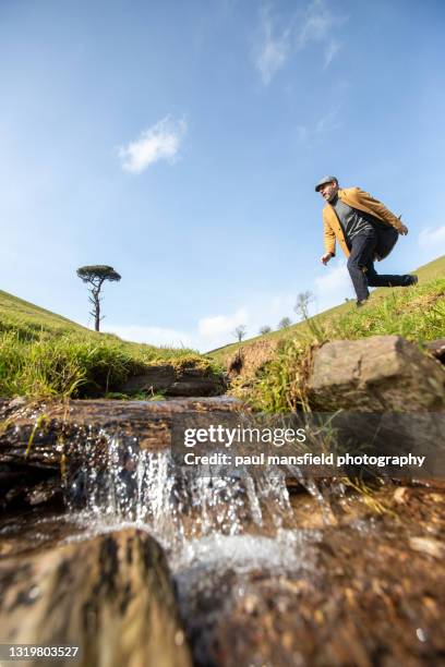 man jumping over stream - leap of faith modo di dire inglese foto e immagini stock