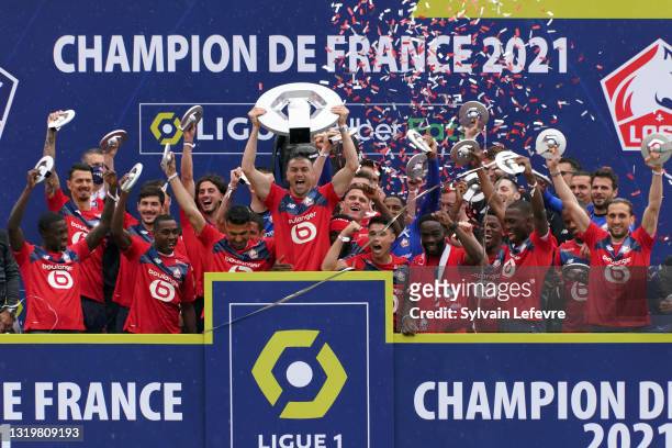Burak Yilmaz and players of Lille OSC celebrate winning League 1 by receiving the trophy at their Luchin training center on May 24, 2021 in Lille,...
