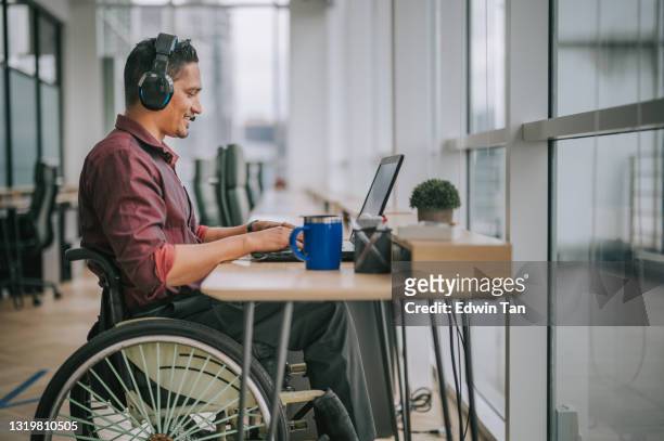 aziatische indische mannelijke witte boordarbeider met handicap op rolstoel die aan de video van de camera spreekt die videoconferentie met zijn bedrijfspartners roept - disability care stockfoto's en -beelden