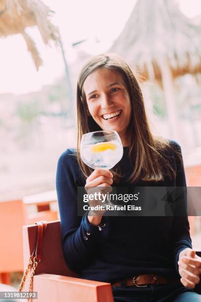 pretty happy woman drinking gin with tonic - gin and tonic stock pictures, royalty-free photos & images