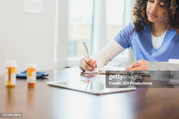 nurse reviews patient's medical record - doctor publication stock pictures, royalty-free photos & images