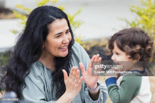 grandmother plays clapping game with grandson - clapping game stock pictures, royalty-free photos & images