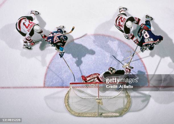 Martin Brodeur#30, Goalkeeper and defensemen Scott Niedermayer and Lyle Odelein for the New Jersey Devils check the attack on goal from Steve Webb...