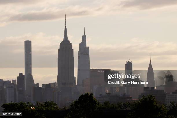 The sun rises behind 432 Park Avenue, the Empire State Building, One Vanderbilt, the MetLife Building and the Chrysler Building on the skyline of...