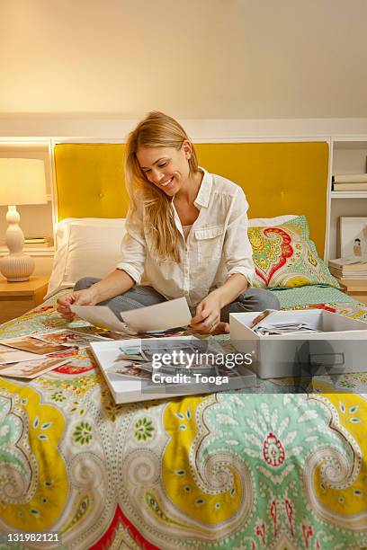 woman looking through old family photos - memories box stock pictures, royalty-free photos & images