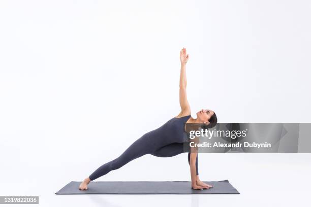 yogi woman practicing yoga on mat on white background in studio - yoga studio - fotografias e filmes do acervo