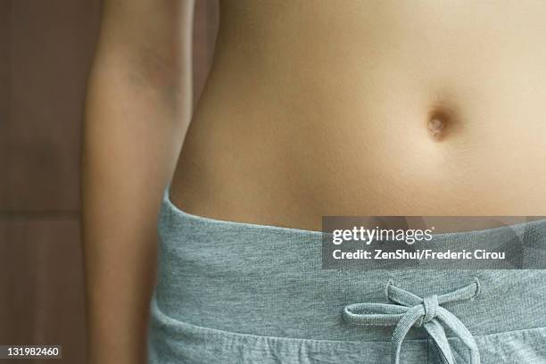 woman's bare stomach, cropped - ombelico foto e immagini stock