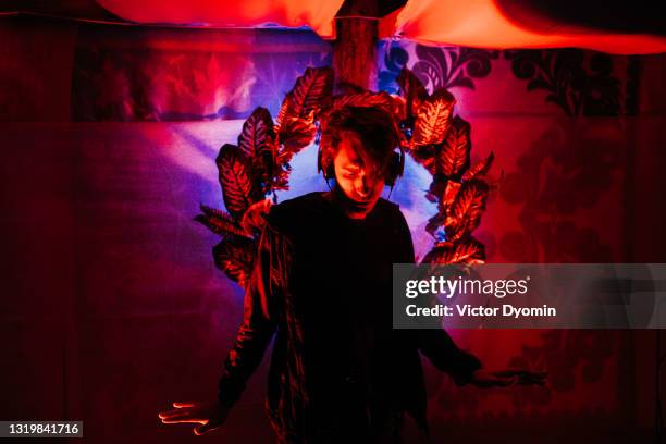 young handsome man in the headphones at the party - man blue background - fotografias e filmes do acervo