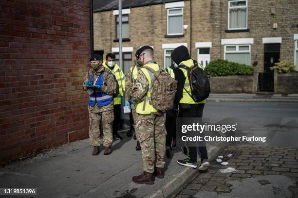 Gunners from the Royal Horse Artillery and Bolton council workers distribute Covid-19 polymerase chain reaction tests to local residents on May 24,...