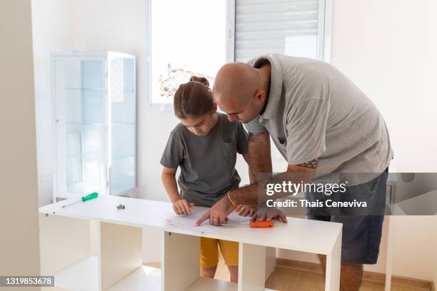 father and son assembling furniture together. diy - escrivaninha stock pictures, royalty-free photos & images