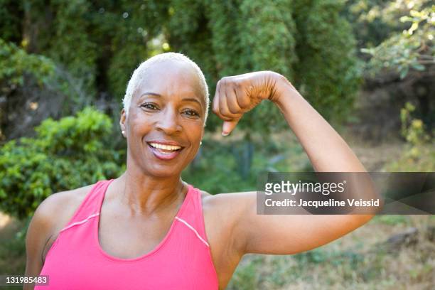 mixed race woman flexing muscles outdoors - california strong stock pictures, royalty-free photos & images