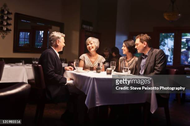 couples enjoying dinner in restaurant together - four people stockfoto's en -beelden