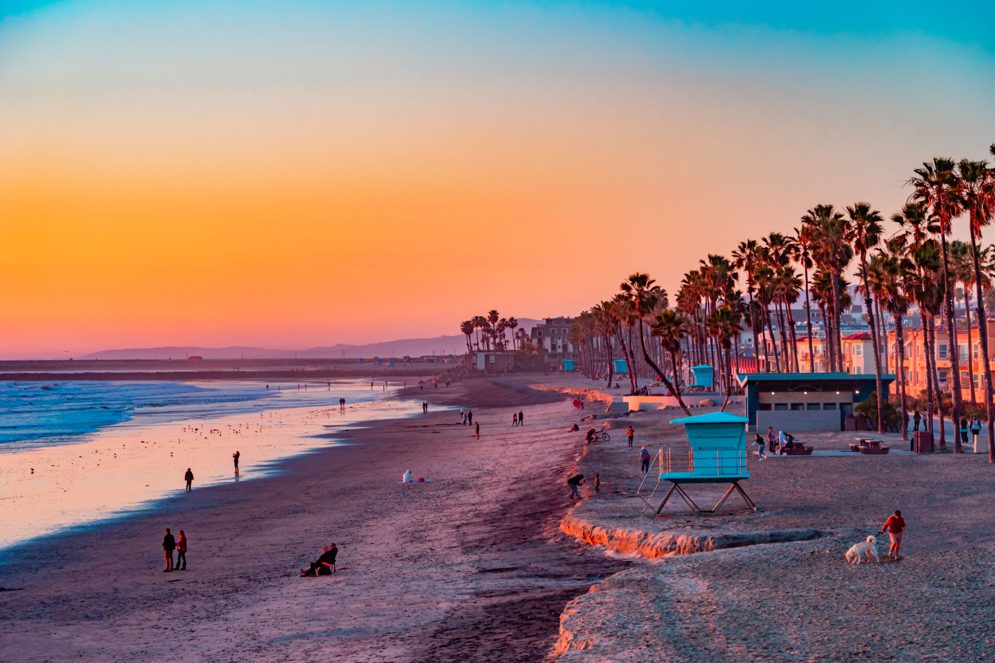 A Oceanside sunset at the beach draws people to it to walk and relax A Oceanside sunset at the beach draws people to it to walk and relax
