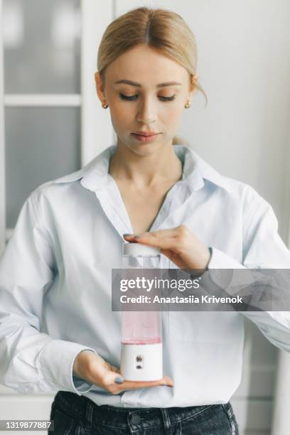 woman holding portable hydrogen water generator on white background. - second half sport stock pictures, royalty-free photos & images