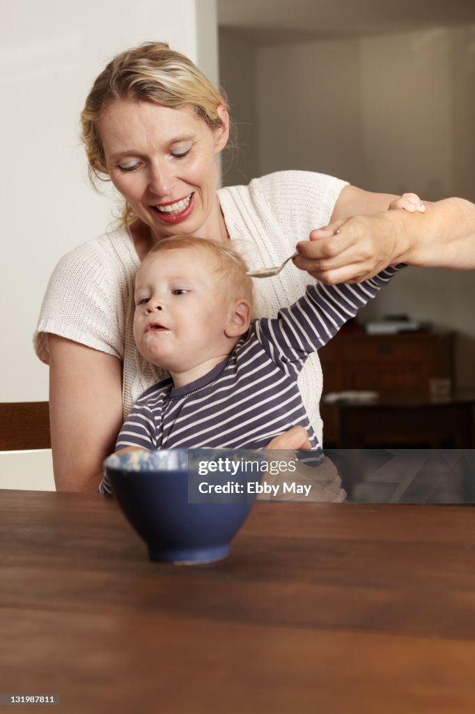 Mother feeding baby boy
