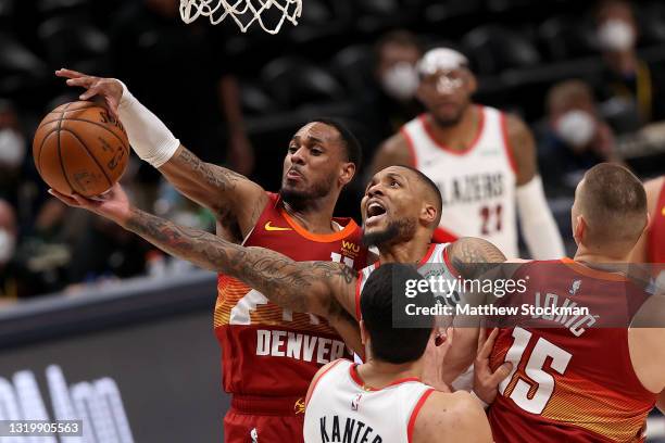 Damian Lillard of the Portland Trail Blazers is blocked going to the basket by Monte Morris of the Denver Nuggets in the fourth quarter during Game...