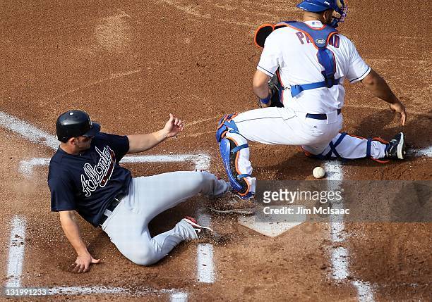 Dan Uggla of the Atlanta Braves scores a run against Ronny Paulino of the New York Mets at Citi Field on September 8, 2011 in the Flushing...